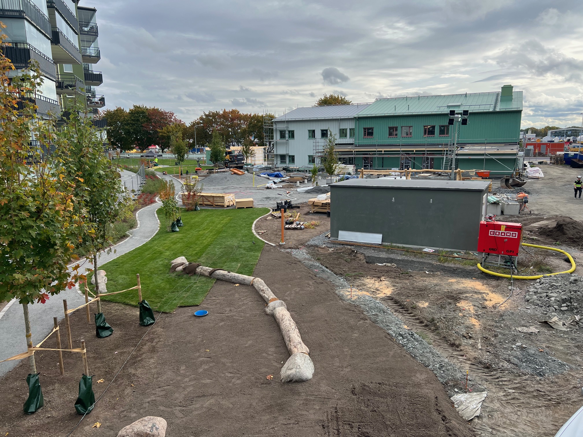 En ny förskola i trä med förskolegård som byggs i ett lägenhetsområde.