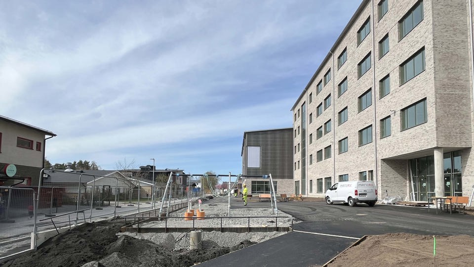 Fasad på hög skola med skolgård i förgrunden.