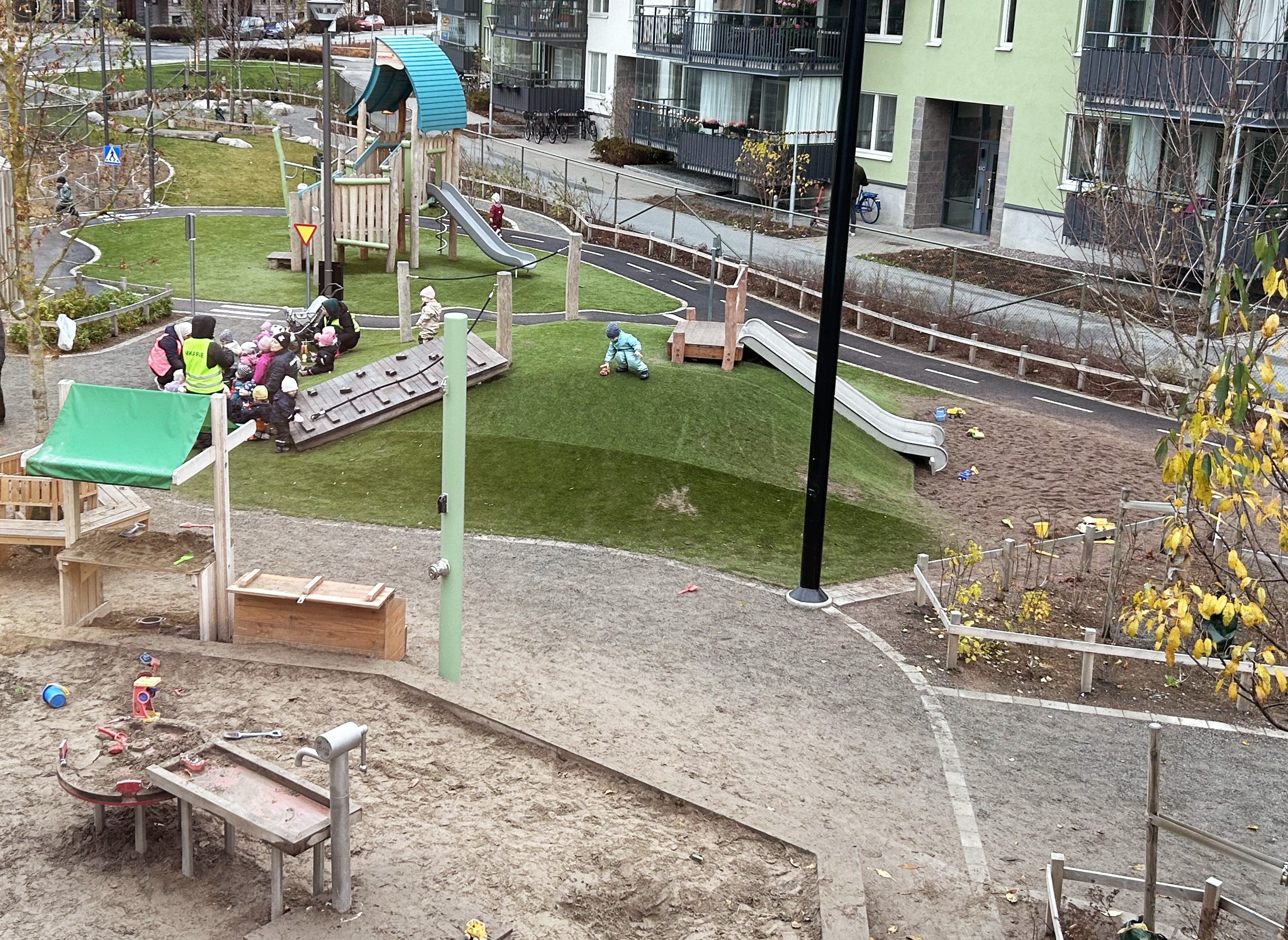 Förskolegård med rutschkana och klätterställningar.