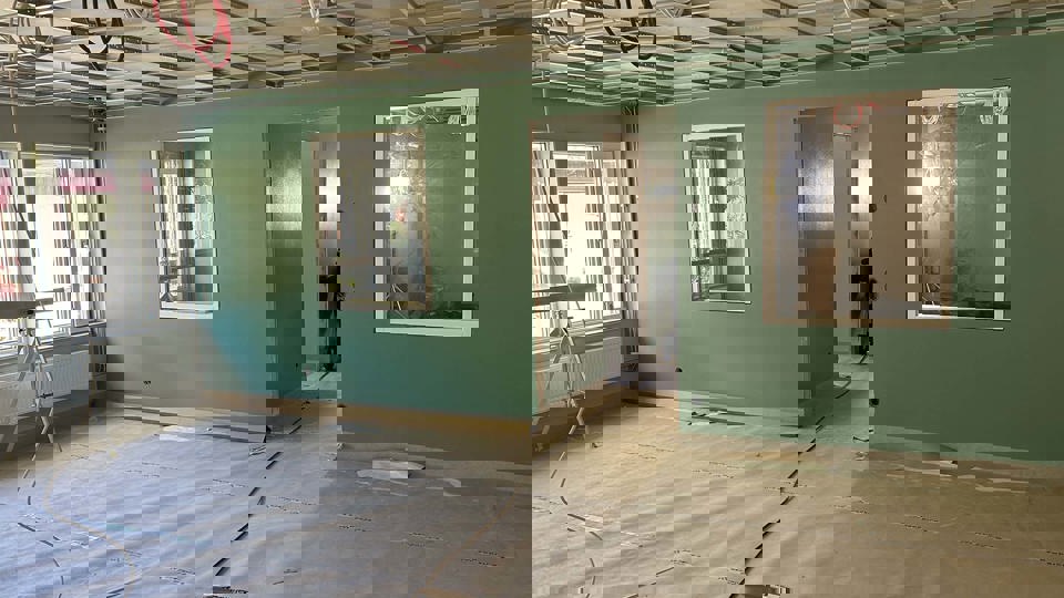 Nymålad grön vägg i en inomhusmiljö som renoveras.