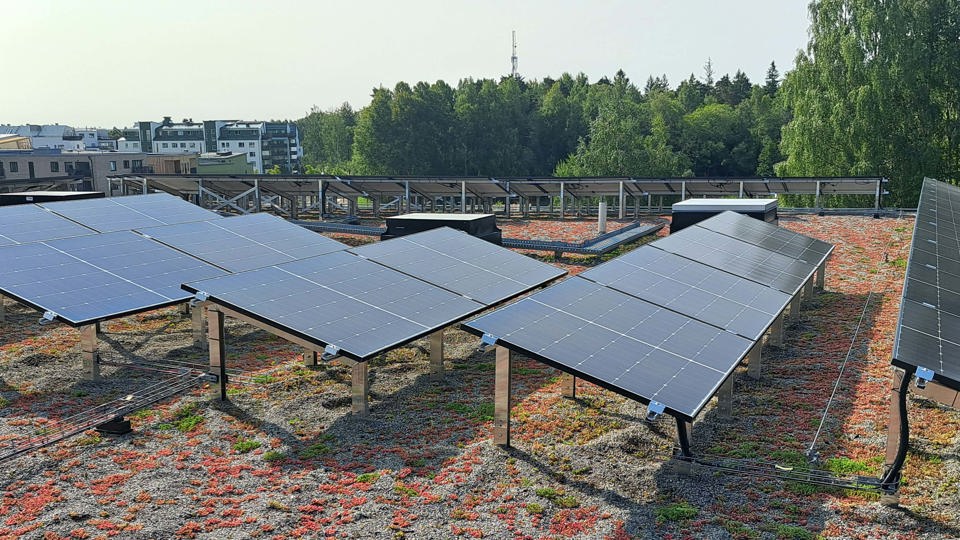 Solcellsanläggning på skoltak med Rosendal i bakgrunden