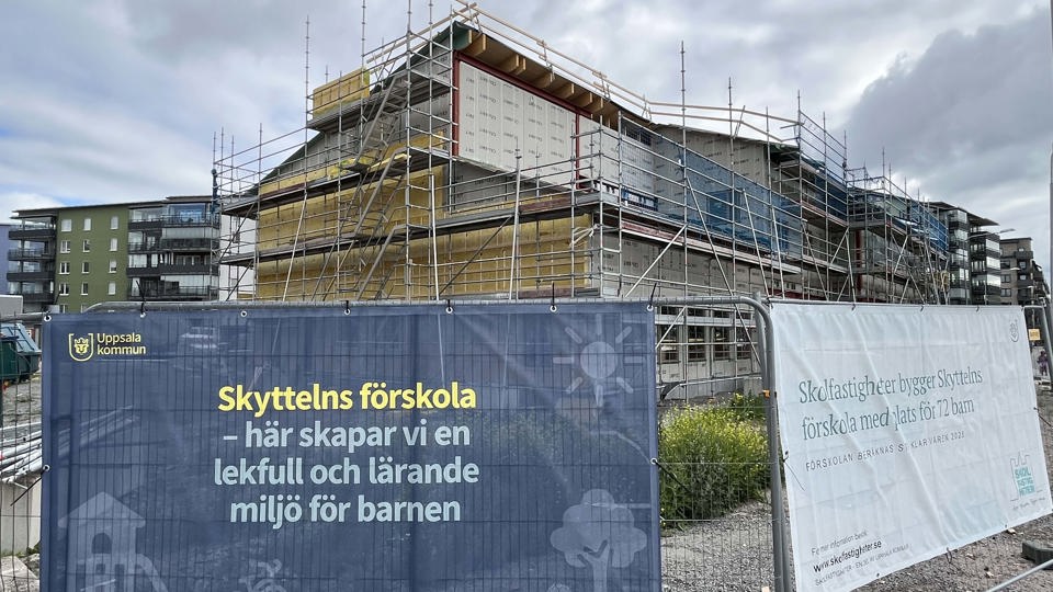 Byggplats för en ny förskola med vepor på stängsel i förgrunden.