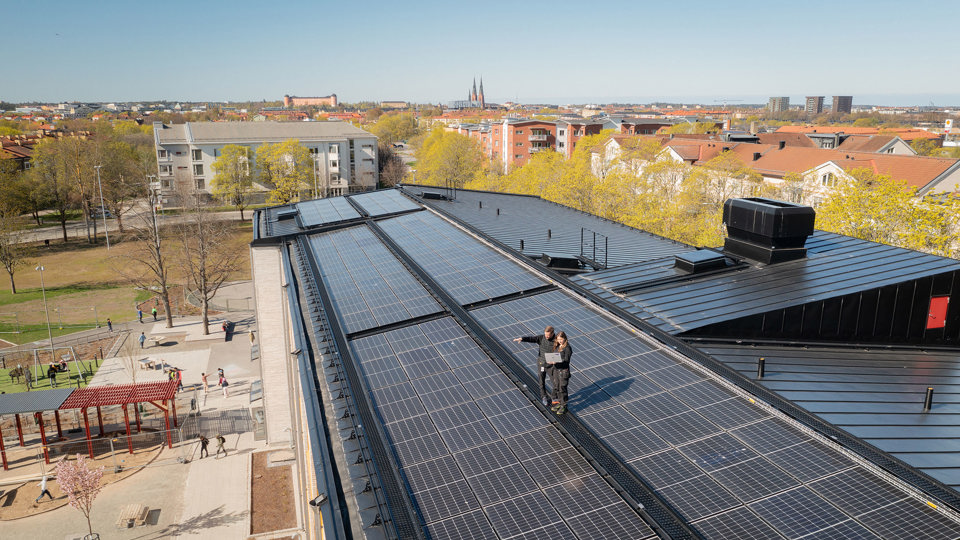 Solcellsanläggning på tak med Uppsala domkyrka i bakgrunden.