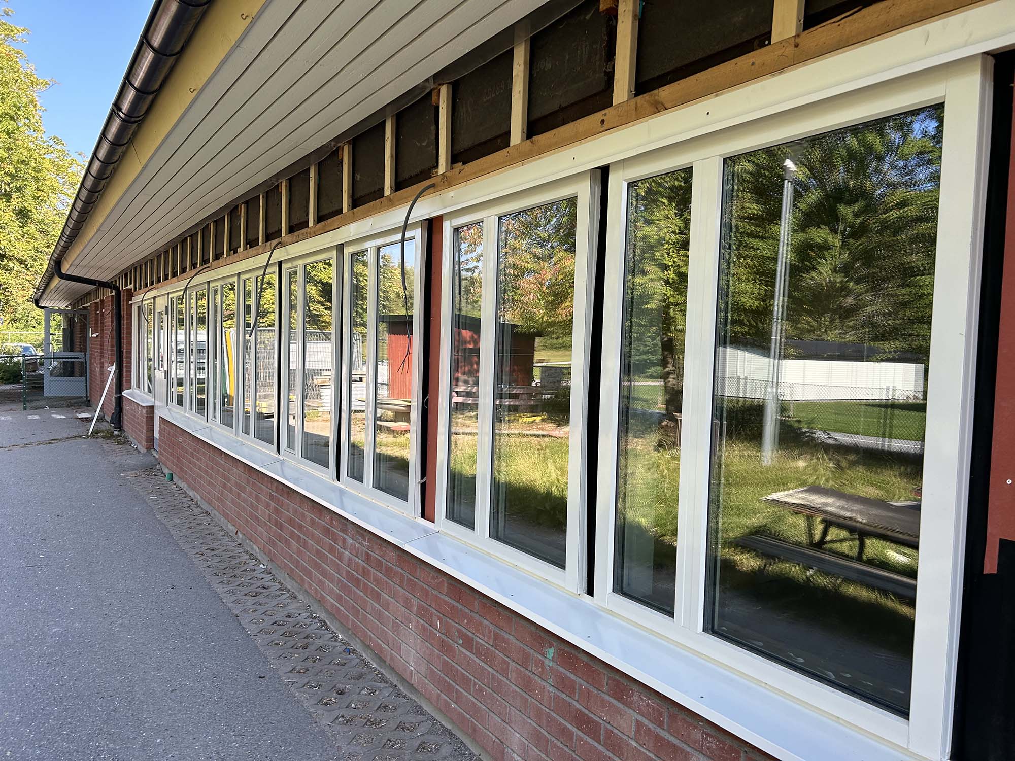 Tegelvägg med nya fönster på en förskola som renoveras.
