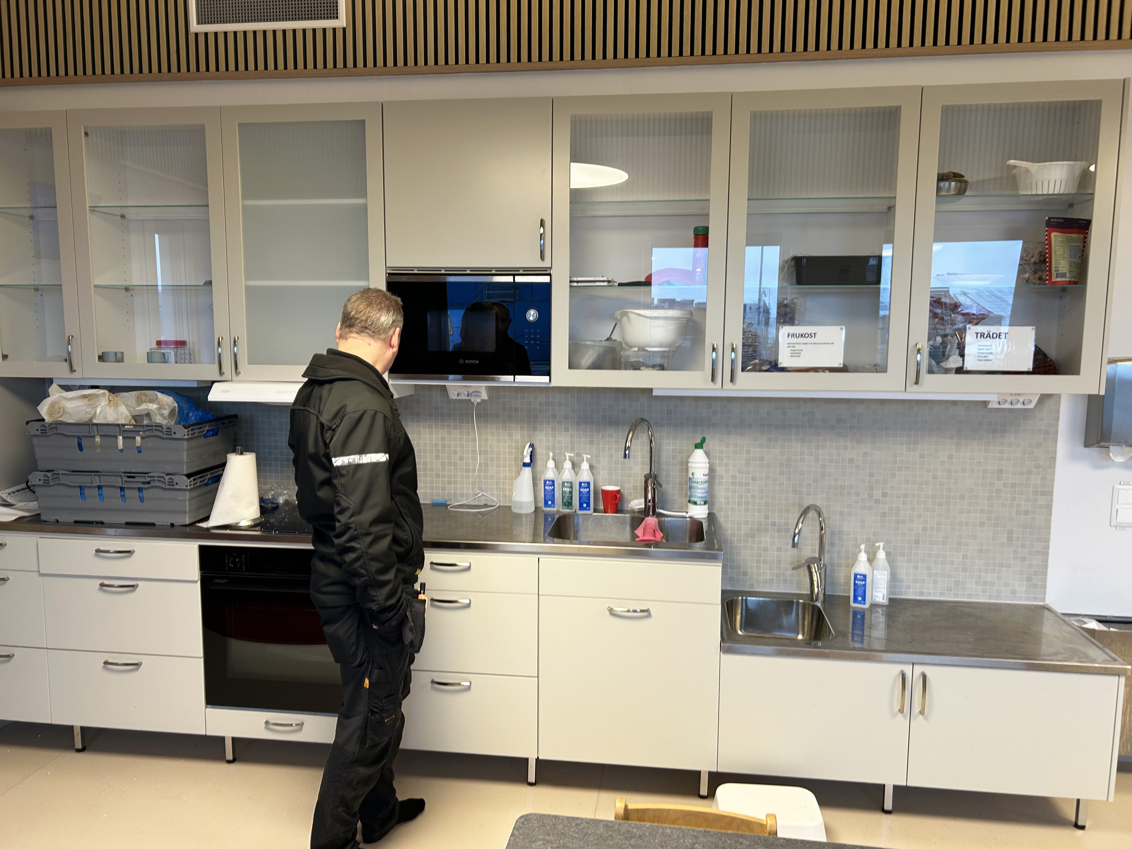 En person står i ett kök och tittar på ett förskolekök i en nybyggd förskola.